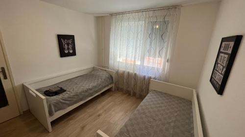 Dormitorio pequeño con cama frente a una ventana en Eni en Pirot