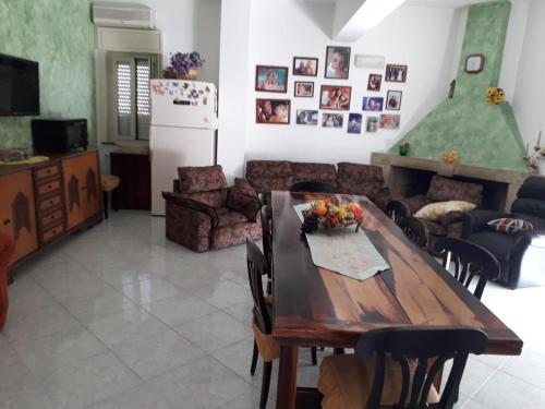 a living room with a wooden table and a kitchen at new mansarda panoramica in Barcellona-Pozzo di Gotto