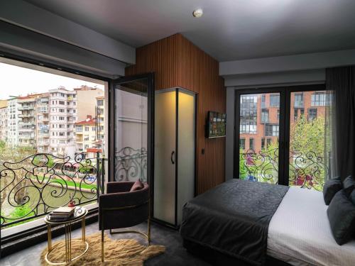 1 dormitorio con 1 cama y balcón en SennaCity Hotel, en Eskisehir