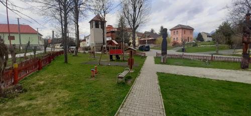 a park with a bench and a playground and a fence at Guest House Mengsdorf in Mengusovce