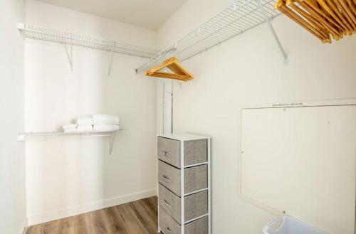 a bathroom with white walls and a shelf with towels at Revela Mountain View in Mountain View
