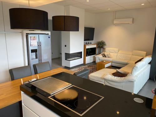 een keuken en een woonkamer met een bank en een tafel bij De Wellnessloft Bocholt in Bocholt