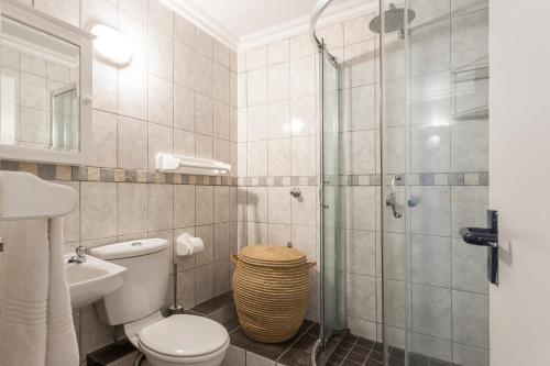 a bathroom with a toilet and a glass shower at Chaka's Cove 66 in Ballito