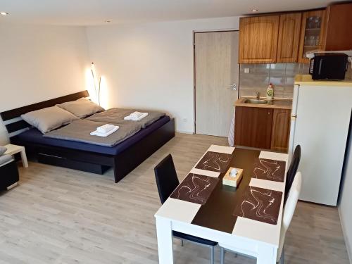 Habitación con cama, mesa y cocina. en Apartmán Patrik, en Valtice