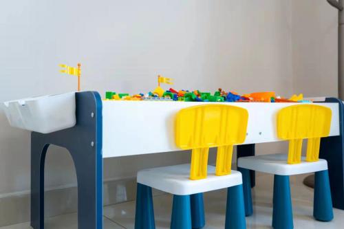 una mesa y dos sillas amarillas en una sala de juegos en Cloud & Sea Boutique Apartment en Rizhao