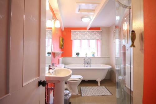 a bathroom with a tub and a toilet and a sink at Trevadlock Manor Self Catering Cottages in Launceston