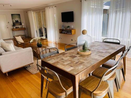 a living room with a wooden table and chairs at The Handbreak in Dunsborough