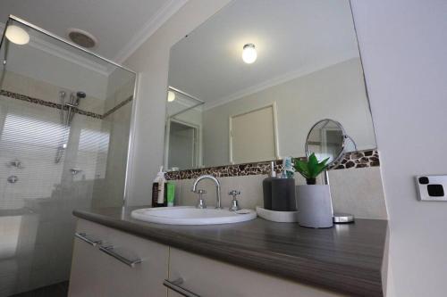 a bathroom with a sink and a large mirror at The Handbreak in Dunsborough