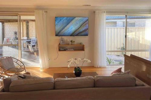 a living room with a couch and a painting on the wall at The Handbreak in Dunsborough
