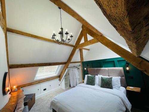 a bedroom with a large bed in the attic at THE APPLE LOFT - Rustic luxury one bed cottage in Strete