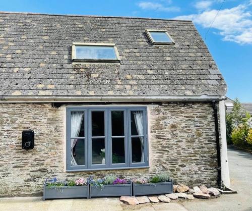 a brick house with a window and some plants at THE APPLE LOFT - Rustic luxury one bed cottage in Strete