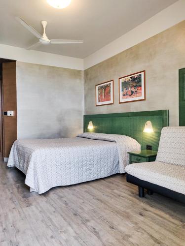 a hotel room with two beds and a chair at Hotel Castello S. Antonio in Lazise