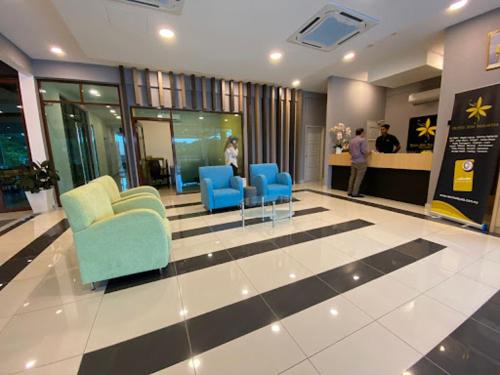 a lobby with blue chairs and people in a building at Hotel Seri Malaysia Seremban in Seremban