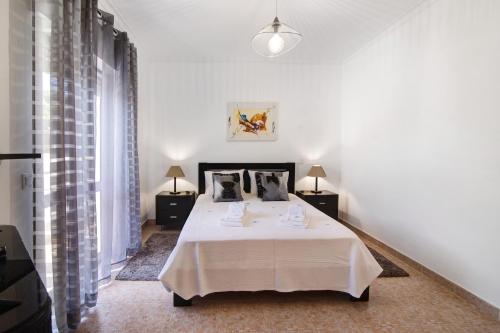 - une chambre blanche avec un lit et deux lampes dans l'établissement Apartamento Kaya, à Albufeira