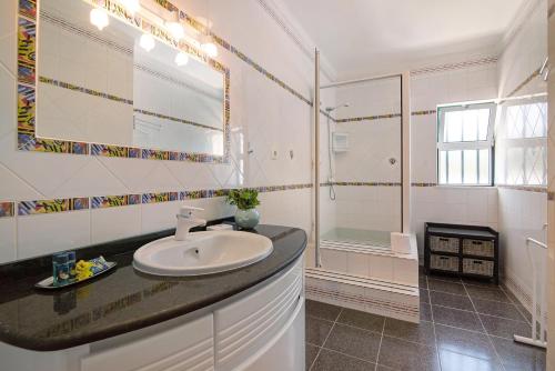 La salle de bains blanche est pourvue d'un lavabo et d'une douche. dans l'établissement Apartamento Kaya, à Albufeira