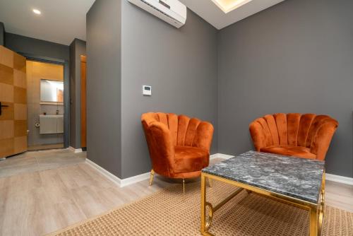 2 sillas naranjas y una mesa en una habitación en 216 Center Suite, en Estambul