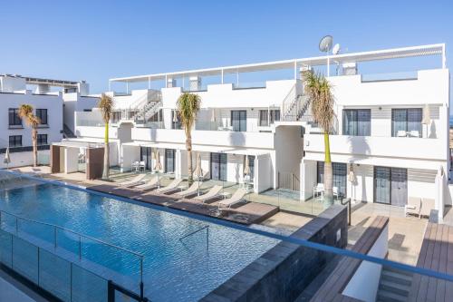 una imagen de una piscina frente a un edificio en LACASA Apartments Cotillo, en Cotillo