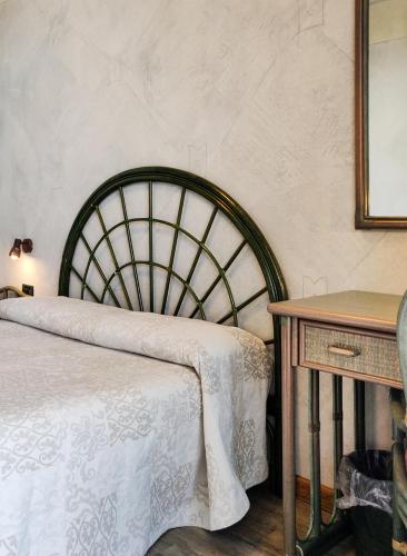 a bedroom with a bed and a wooden table at Hotel Castello S. Antonio in Lazise