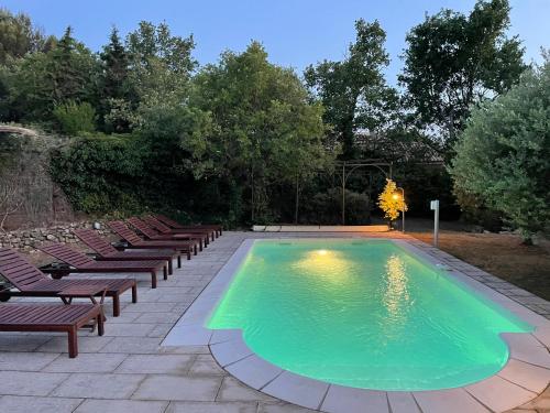 - une piscine avec des chaises et un groupe dans l'établissement Magnifique villa -piscine privée vue Mont Ventoux, à Malemort-du-Comtat