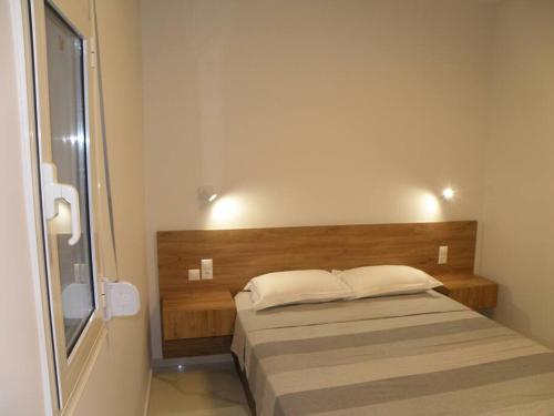 a bedroom with a bed with a wooden headboard at Modern lifestyle flat close to the sea. in Gázion