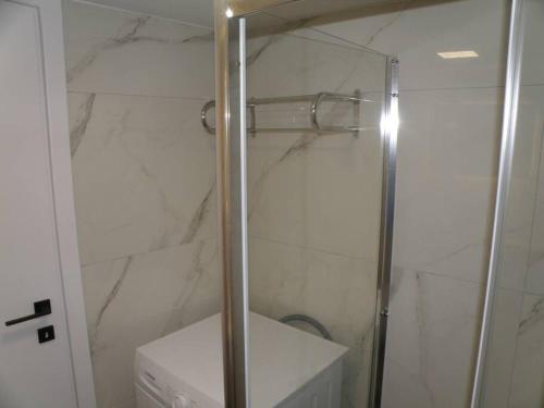 a shower with a glass door in a bathroom at Modern lifestyle flat close to the sea. in Gázion