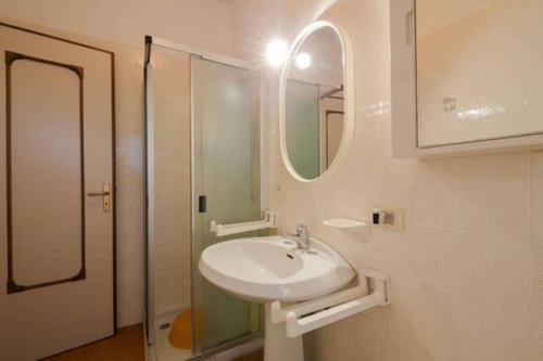 a white bathroom with a sink and a mirror at Casa al mare Santo Stefano al Mare in Santo Stefano al Mare