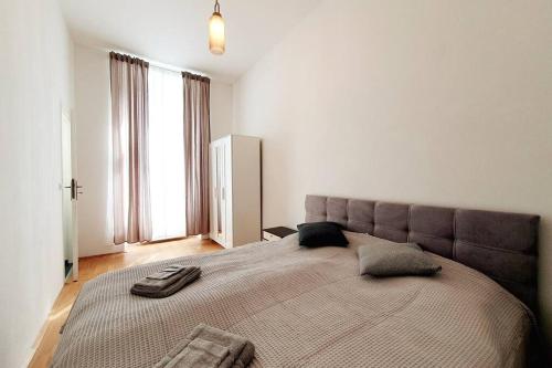 een slaapkamer met een groot bed met 2 kussens erop bij Savoir Vivre Apartments Rosinagasse in Wenen