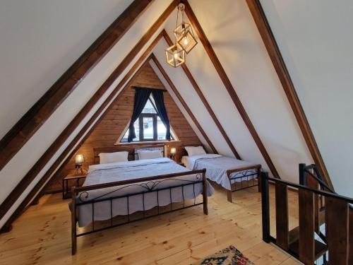 a attic bedroom with two beds and a window at Kazbegi Hut Cottage in Kazbegi