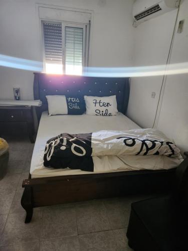 a bedroom with a bed with a blue headboard at בית הנשיא in Safed