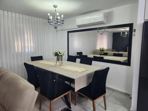 a dining room table with chairs and a large mirror at בית הנשיא in Safed