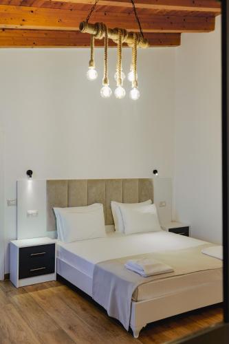 a bedroom with a large white bed and a chandelier at Venti et Maris in Ksamil