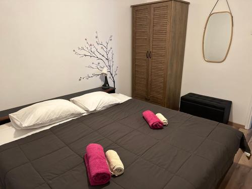 um quarto com uma cama com duas almofadas cor-de-rosa em Šibenik apartment em Sibenik