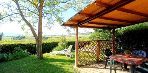 a patio with a table and chairs and a fence at agriturismo macchia al pino in Pomaia