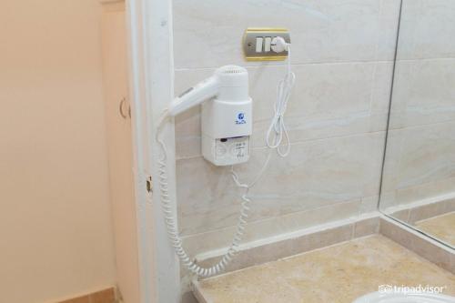 um secador de cabelo pendurado numa parede na casa de banho em Halomy Sharm Resort em Sharm El Sheikk