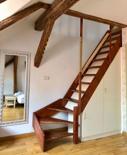 a wooden staircase in a living room with a mirror at Dolce Vita Suites Boutique in Prague
