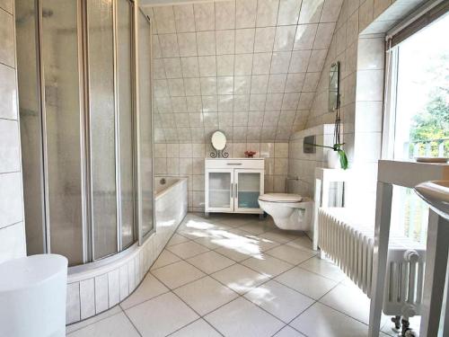 a bathroom with a shower and a toilet and a sink at Ferienhaus Lütt Matten in Wustrow