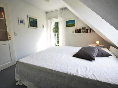 a bedroom with a white bed and a window at Ferienhaus Lütt Matten in Wustrow