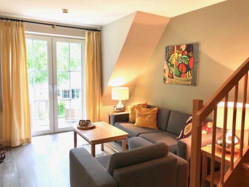 ein Wohnzimmer mit Sofa und Tisch in der Unterkunft Haus Kranich App 422 in Dierhagen