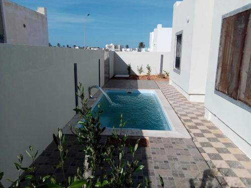 a swimming pool in the courtyard of a house at Djerba La Douce in Houmt Souk