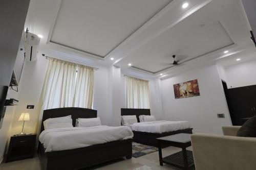 a hotel room with two beds and a couch at The White Lotus in Gaya
