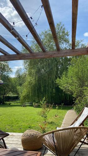 a chair sitting on a deck in a yard at Pool house-L'hirondelle de Sermizelles- grand jardin, calme et nature aux portes du Morvan in Sermizelles