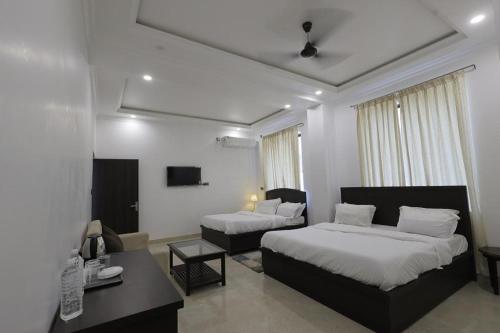 a bedroom with two beds and a couch and a table at The White Lotus in Gaya