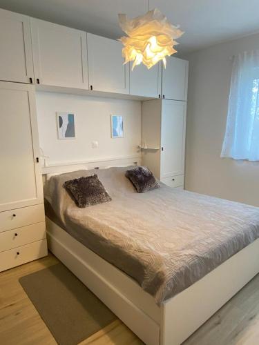 a bedroom with a bed and a chandelier at MINT&ROSE in Peroj