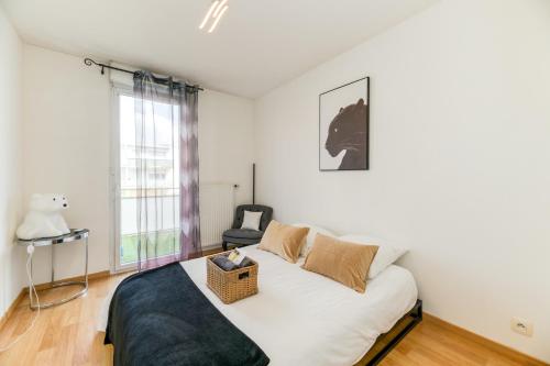 a bedroom with a white bed with a basket on it at Le Bali- Garage- Terrasse- Relaxant- Belle Vue in Grenoble