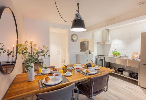 Il comprend une cuisine et une salle à manger avec une table et des chaises en bois. dans l'établissement La Chatelaine, à Egmond aan Zee