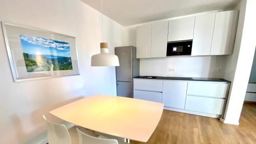 Una pequeña cocina con una mesa y un refrigerador. en Nautilus-Bay Suites - Zweizimmer-Suite 410, en Zavala