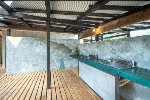 cocina con fregadero y terraza de madera en LOOF Tiny House Camp en Fuefuki