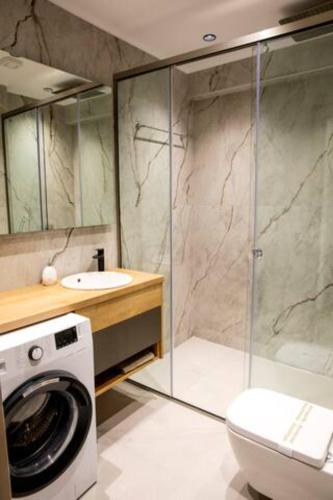 a bathroom with a washing machine and a toilet at Magdalena Suite 1,0 in Heraklio