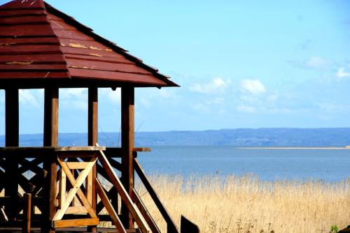 a small wooden building next to a body of water at Zalewowo domki letniskowe in Kąty Rybackie