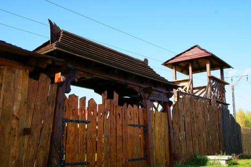 drewniany płot z drewnianym domem za nim w obiekcie Zalewowo domki letniskowe w Kątach Rybackich